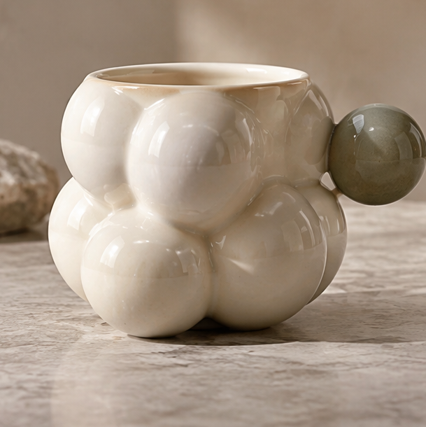 FEASTORI ivory bubble-shaped ceramic mug with a grey-green spherical handle
